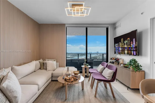 a living room with furniture and a floor to ceiling window