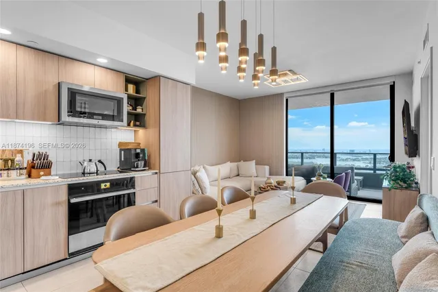 a living room with furniture kitchen view and a large window