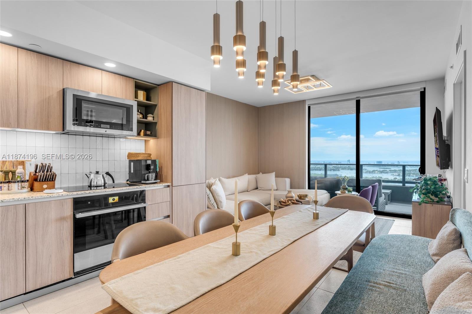 a living room with furniture kitchen view and a large window