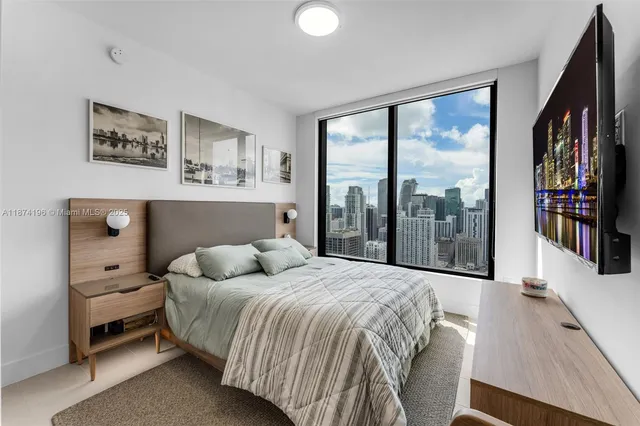 a bedroom with a bed and painting on the wall