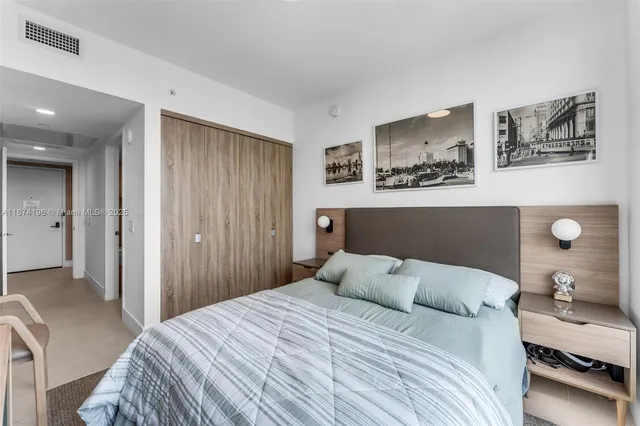 a spacious bedroom with a bed a window and a chandelier