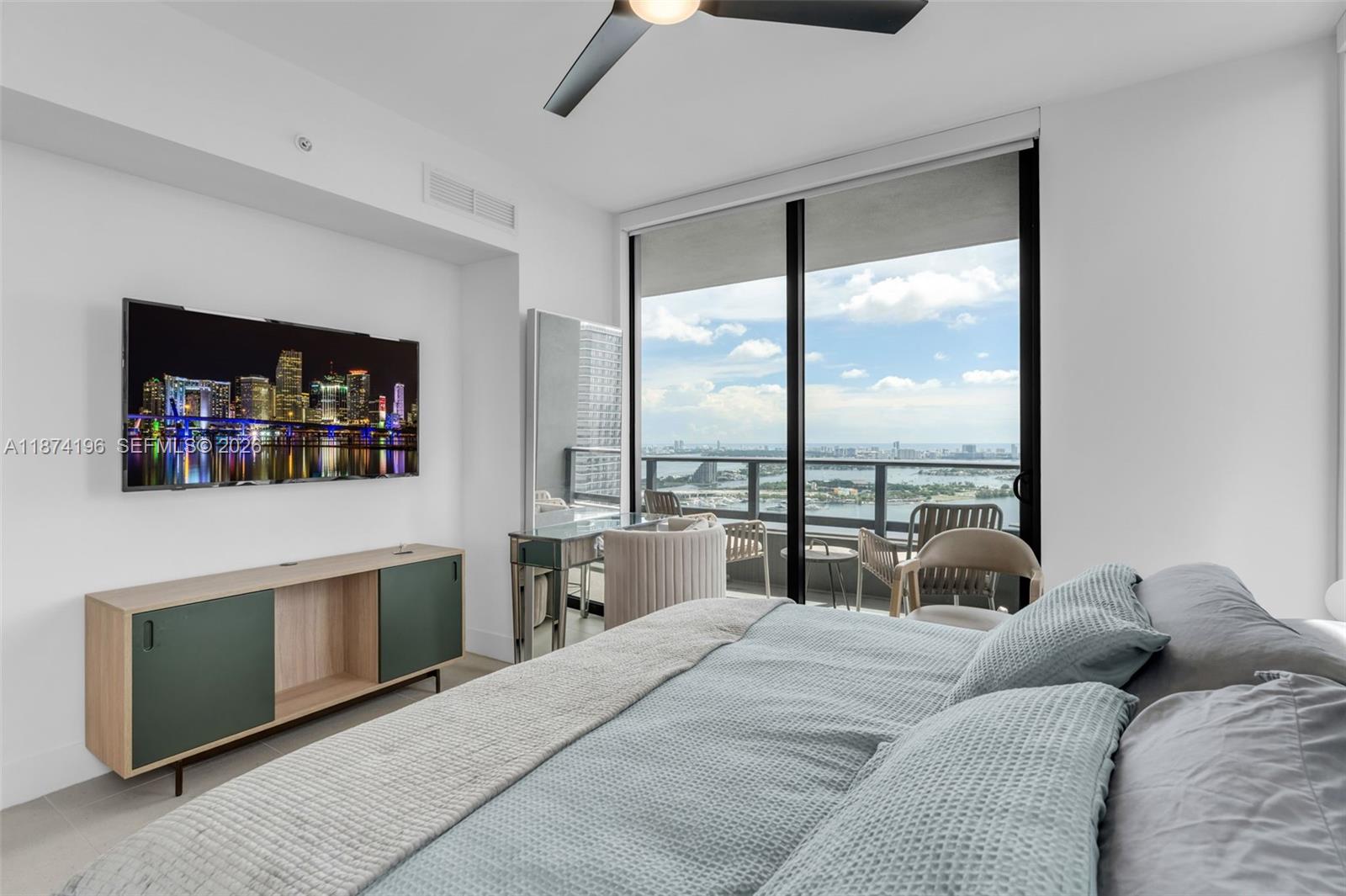 159 Northeast 6th Street, Unit 4016 Miami, FL 33132 - Photo 17 of 50 a bedroom with a bed a couch and a large window