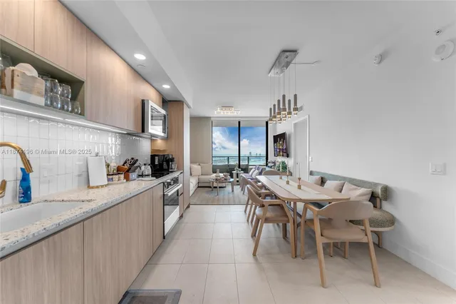 a living room with furniture kitchen view and a large window