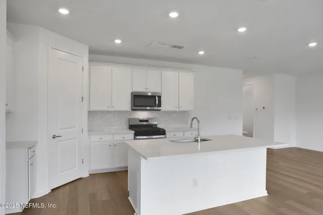 a kitchen with stainless steel appliances a sink and a large window