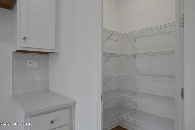 a kitchen with stainless steel appliances granite countertop white cabinets and a stove a oven with white countertops