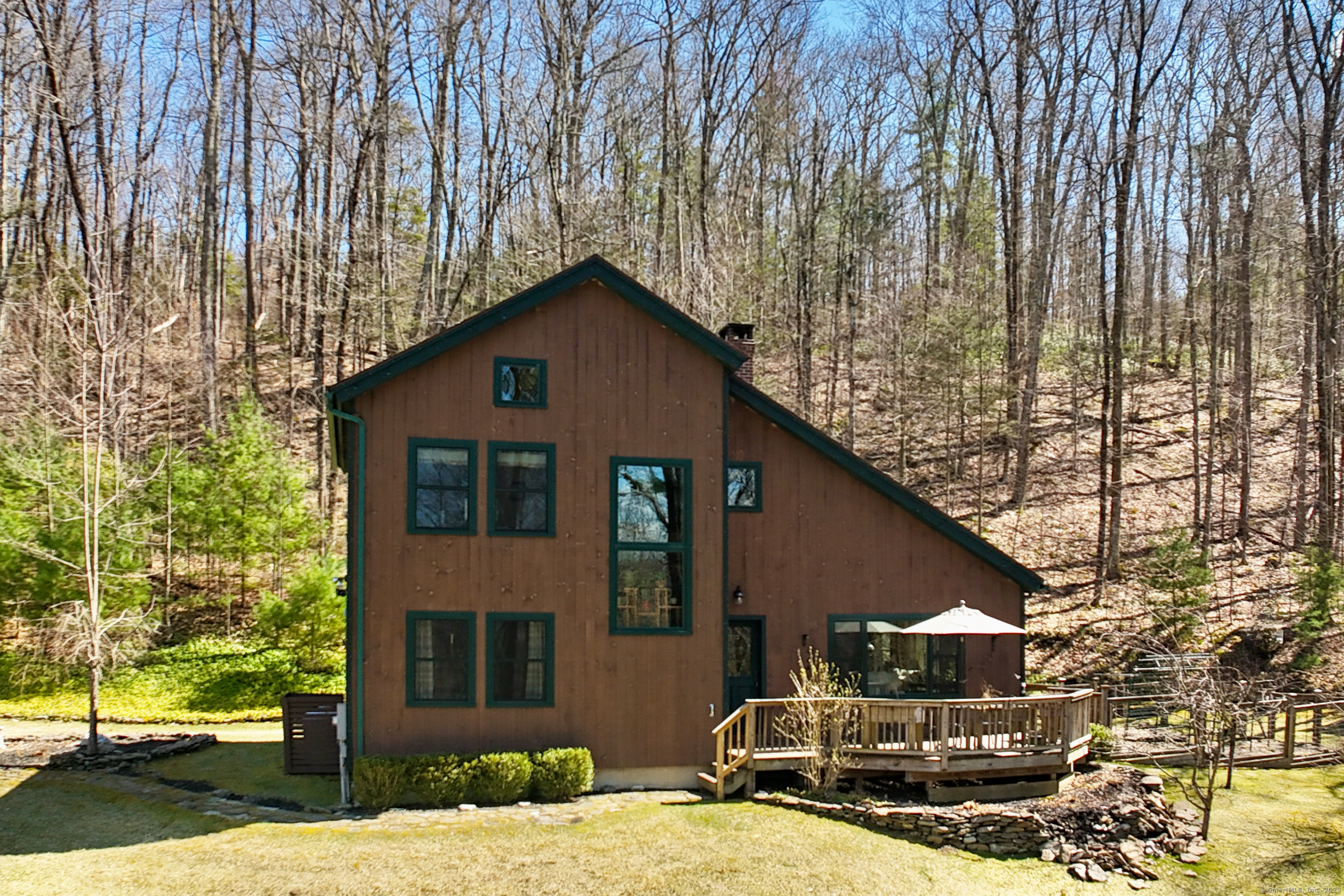 a front view of a house with large trees