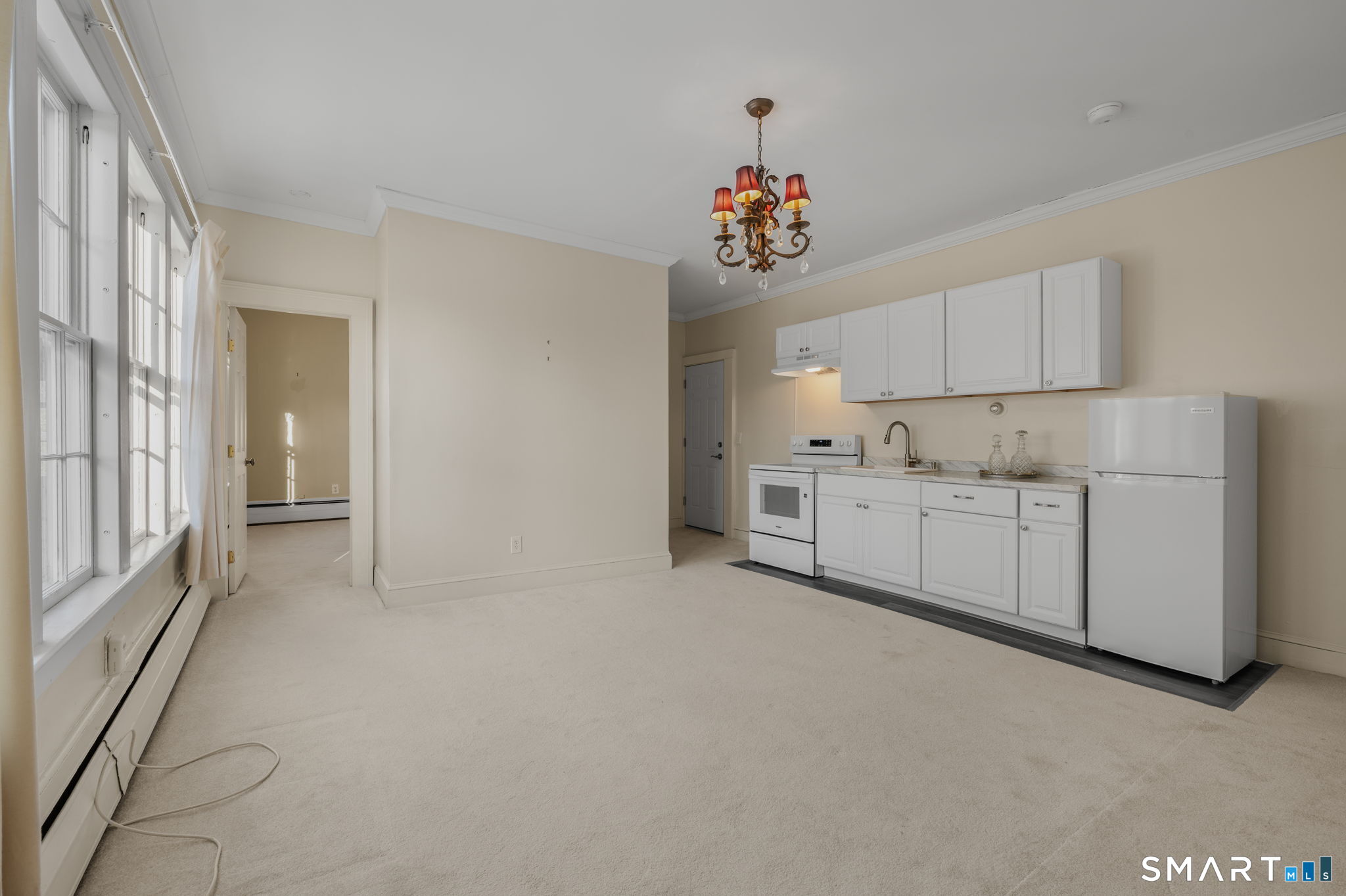 9 Lyme Street, Unit 7 Old Lyme, CT 06371 - Photo 11 of 23 a view of a kitchen with white cabinets and chandelier
