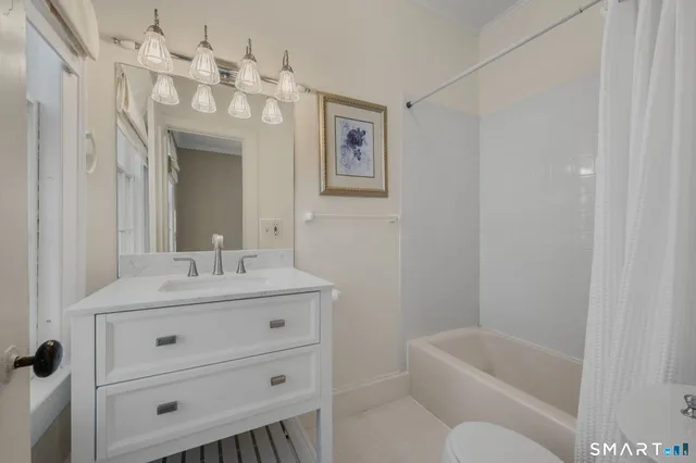 a bathroom with a tub a sink and mirror