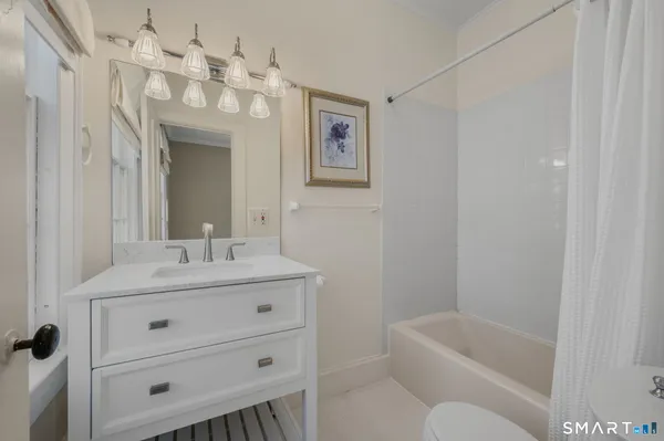a bathroom with a tub a sink and mirror