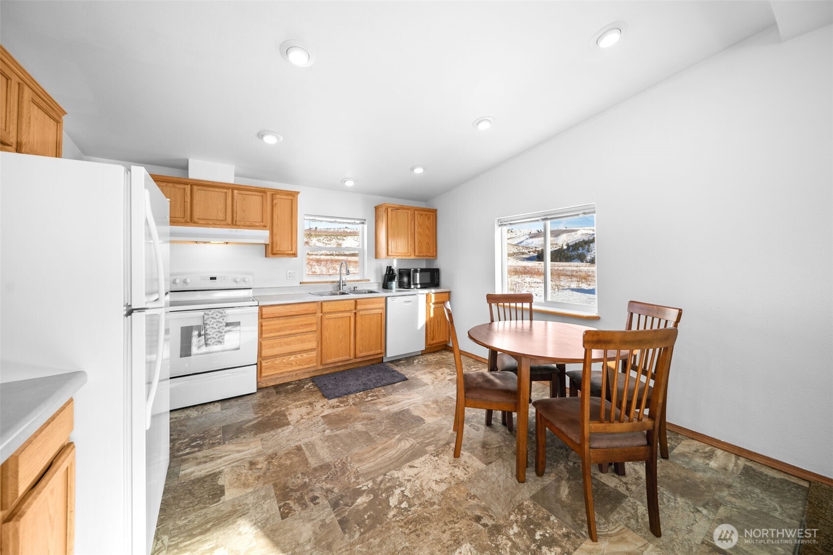565 Boyd Loop Road Manson, WA 98831 - Photo 5 of 27 a kitchen with a table chairs microwave and cabinets