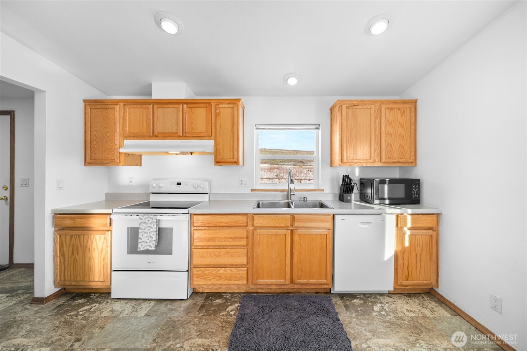 565 Boyd Loop Road Manson, WA 98831 - Photo 7 of 27 a kitchen with stainless steel appliances granite countertop a sink stove and window