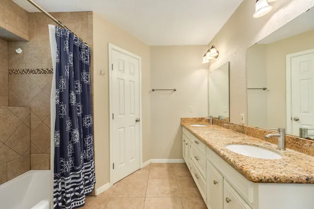 a bathroom with a granite countertop sink a mirror and a shower