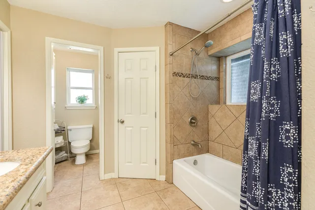 a bathroom with a granite countertop toilet a sink and bathtub