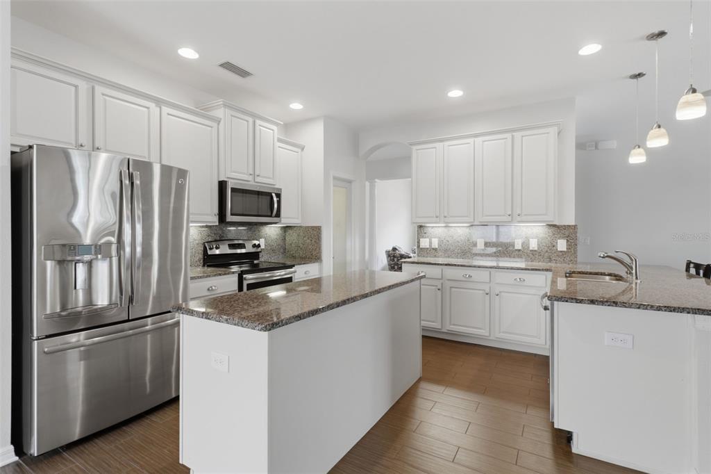 34144 Spring Oak Trail Wesley Chapel, FL 33545 - Photo 2 of 37 a kitchen with granite countertop a refrigerator stove and microwave