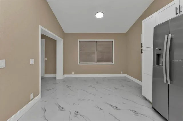 an empty room with a door and windows