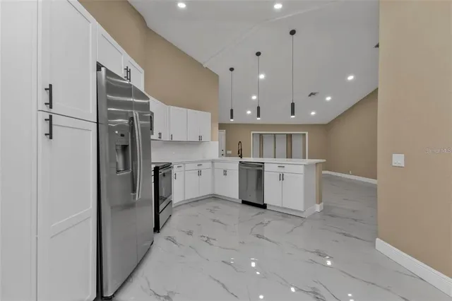 a kitchen with a refrigerator sink and cabinets