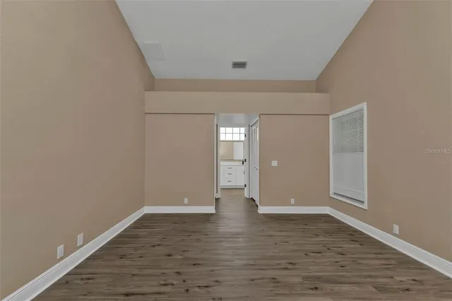 a view of an empty room with wooden floor