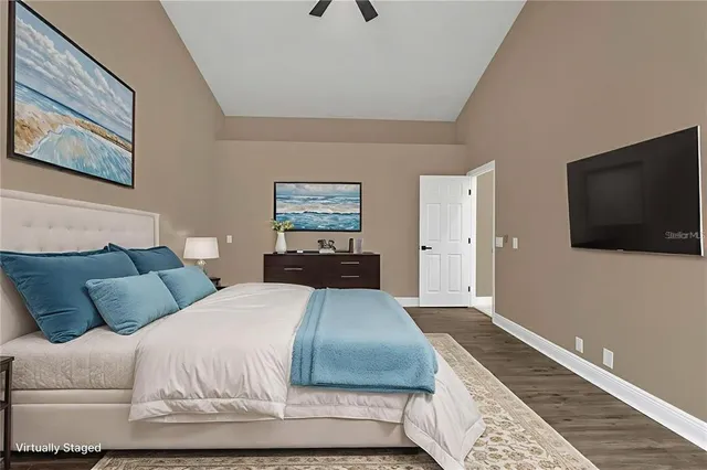 a bedroom with a large bed and a flat screen tv
