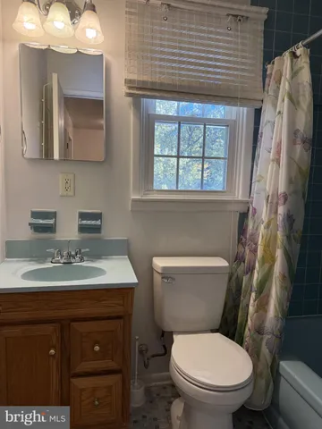 a bathroom with a toilet sink vanity and mirror
