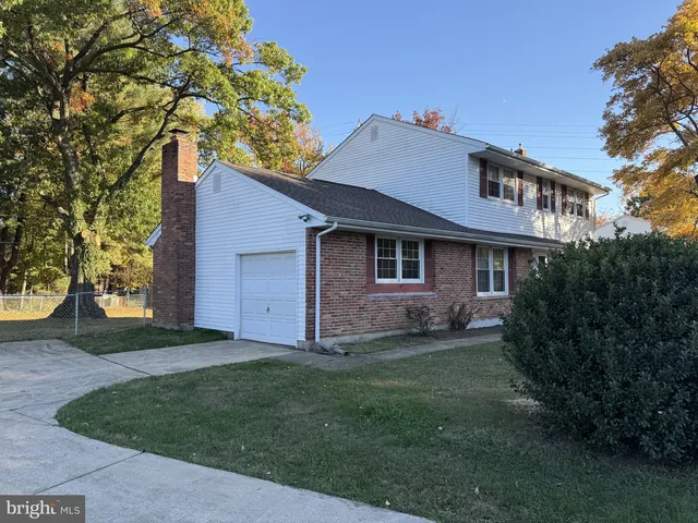 a brick house with a large tree in front of it