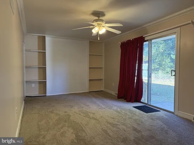 an empty room with closet and chandelier fan