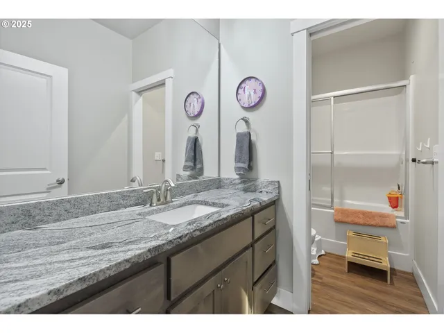 a bathroom with a granite countertop sink and a mirror