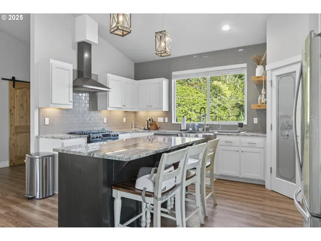 a kitchen with kitchen island granite countertop a sink cabinets and stainless steel appliances