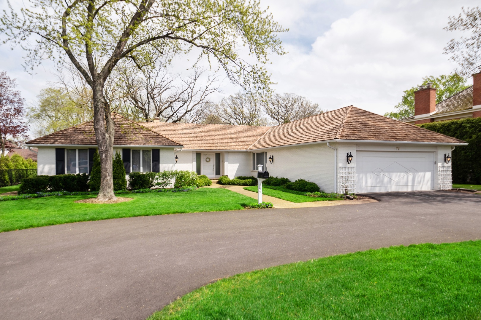 77 Brandon Road Northfield, IL 60093 - Photo 1 of 18 a front view of a house with a yard and garage