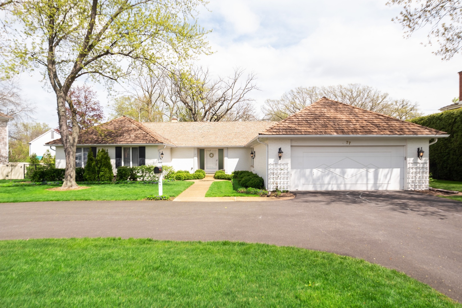 77 Brandon Road Northfield, IL 60093 - Photo 2 of 18 a front view of a house with a yard and garage
