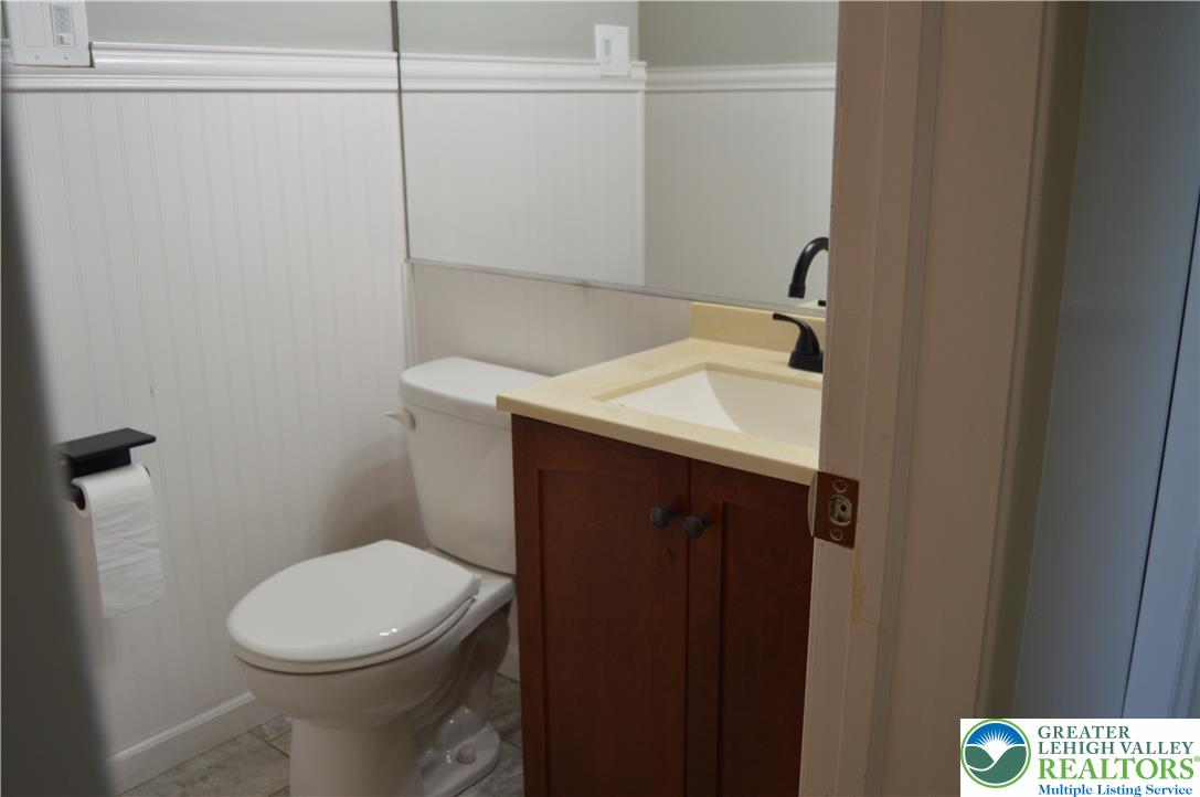 1819 Blue Barn Road Orefield, PA 18069 - Photo 17 of 21 Functional full bathroom featuring a vanity with integrated sink and a toilet, all set against a wainscoted wall.