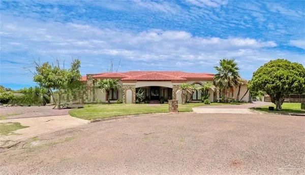 a front view of house with yard and trees