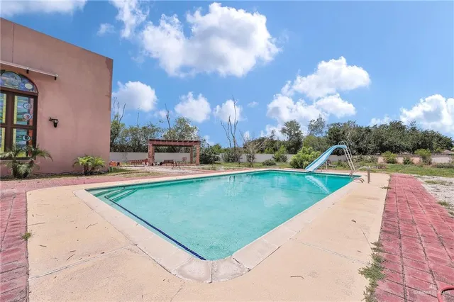 a living room with couches a fireplace with kitchen view