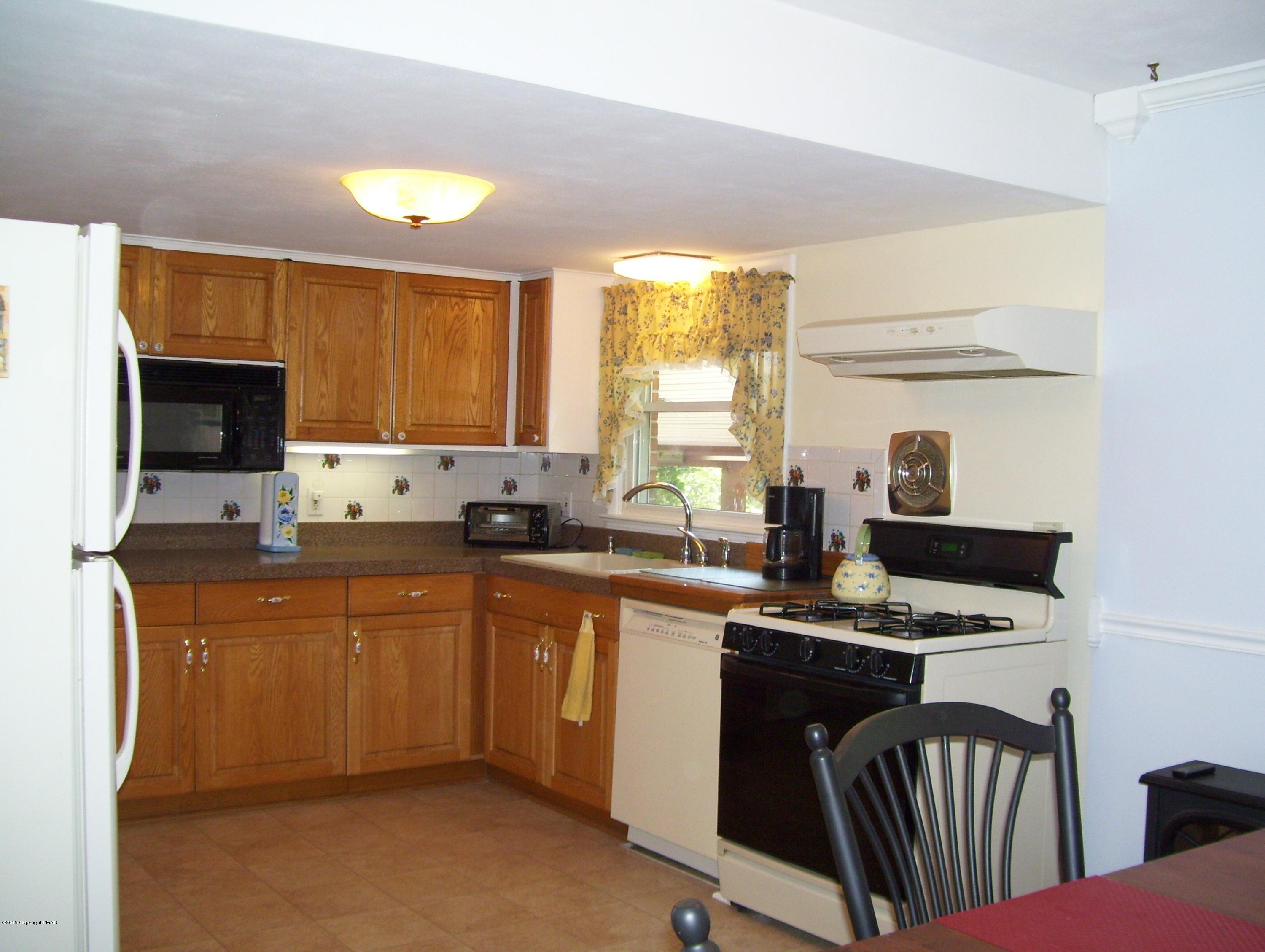 2610 Brookdale Road Scotrun, PA 18355 - Photo 19 of 37 a kitchen with stainless steel appliances granite countertop a sink a stove a microwave a refrigerator and cabinets