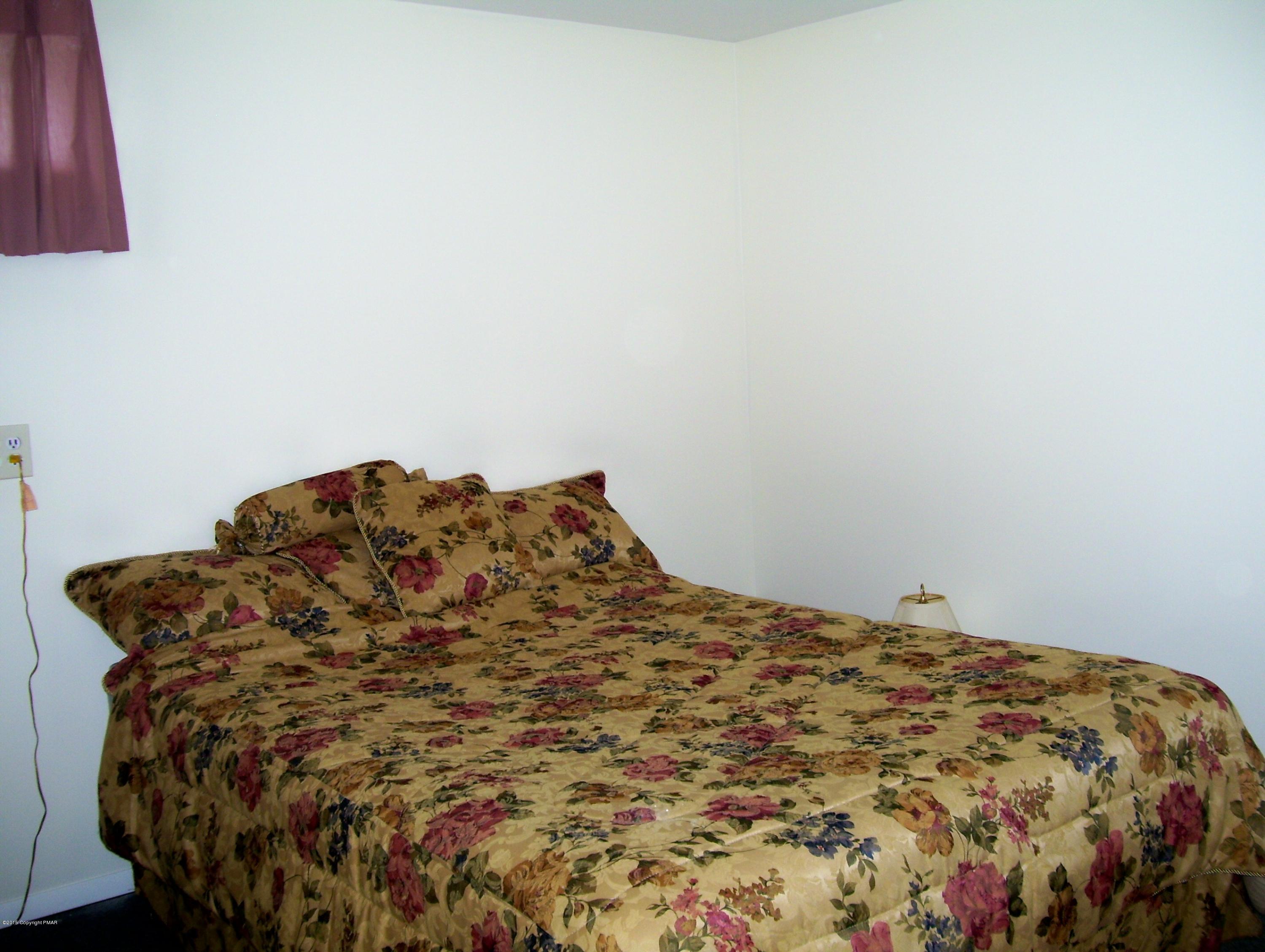 2610 Brookdale Road Scotrun, PA 18355 - Photo 28 of 37 a bed sitting in a bedroom next to a lamp