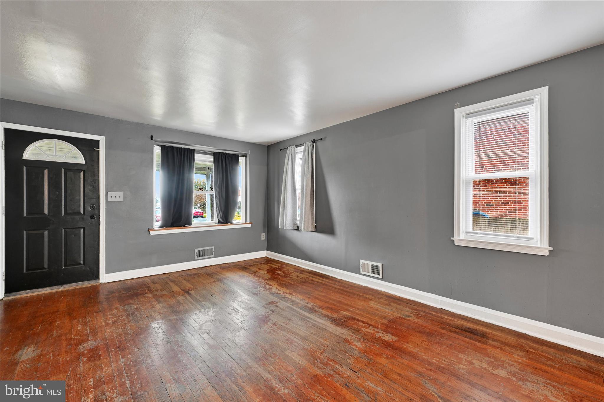 8028 Kavanagh Road Dundalk, MD 21222 - Photo 4 of 29 a view of an empty room with wooden floor and a window