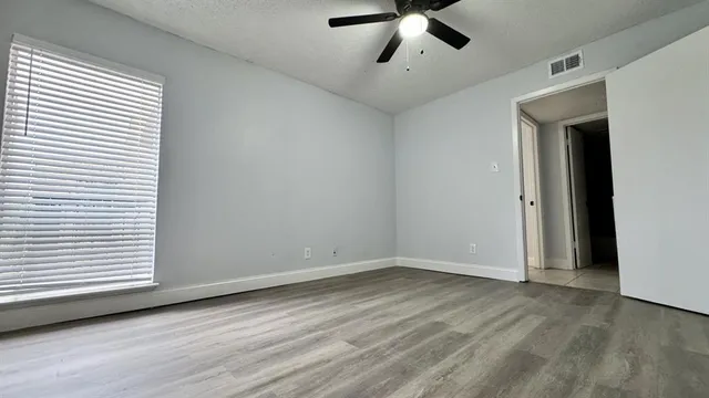 a view of a kitchen with refrigerator and wooden floor