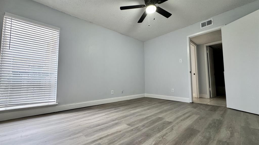 5616 Boca Raton Boulevard, Unit 238 Fort Worth, TX 76112 - Photo 5 of 11 a view of an empty room with wooden floor and a window