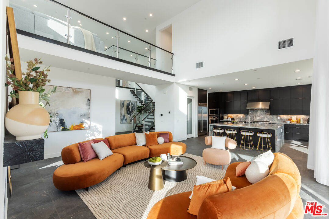 a living room with furniture kitchen view and a flat screen tv