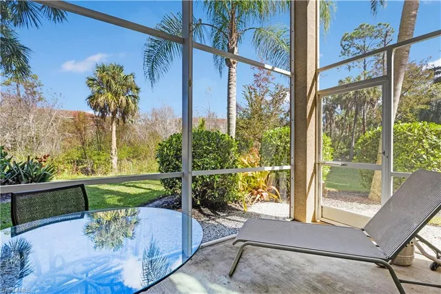 a porch with a table and chairs and potted plants