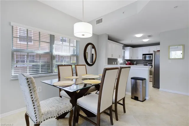a dining room with furniture and a large window