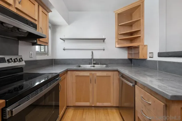 a kitchen with stainless steel appliances granite countertop a sink stove and cabinets