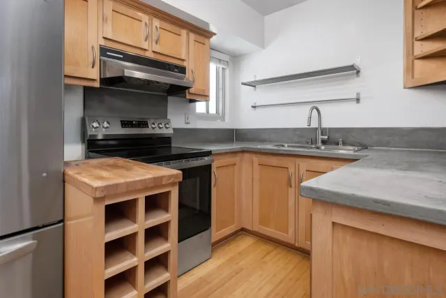 a kitchen with stainless steel appliances granite countertop a sink stove and cabinets