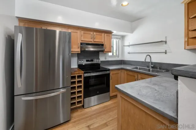 a kitchen with stainless steel appliances a refrigerator a sink a stove and cabinets