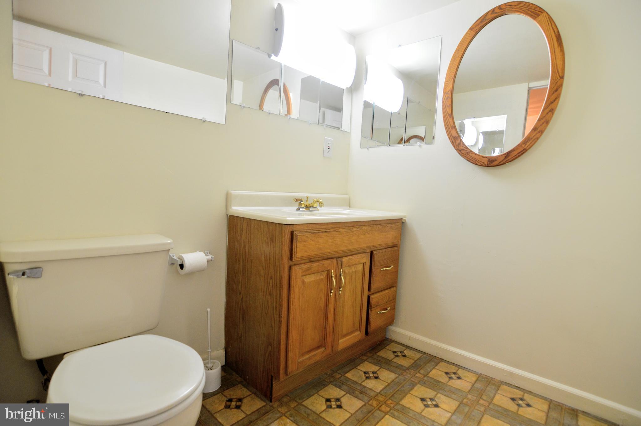 6802 Killarney Street Clinton, MD 20735 - Photo 11 of 19 a bathroom with a sink mirror and toilet
