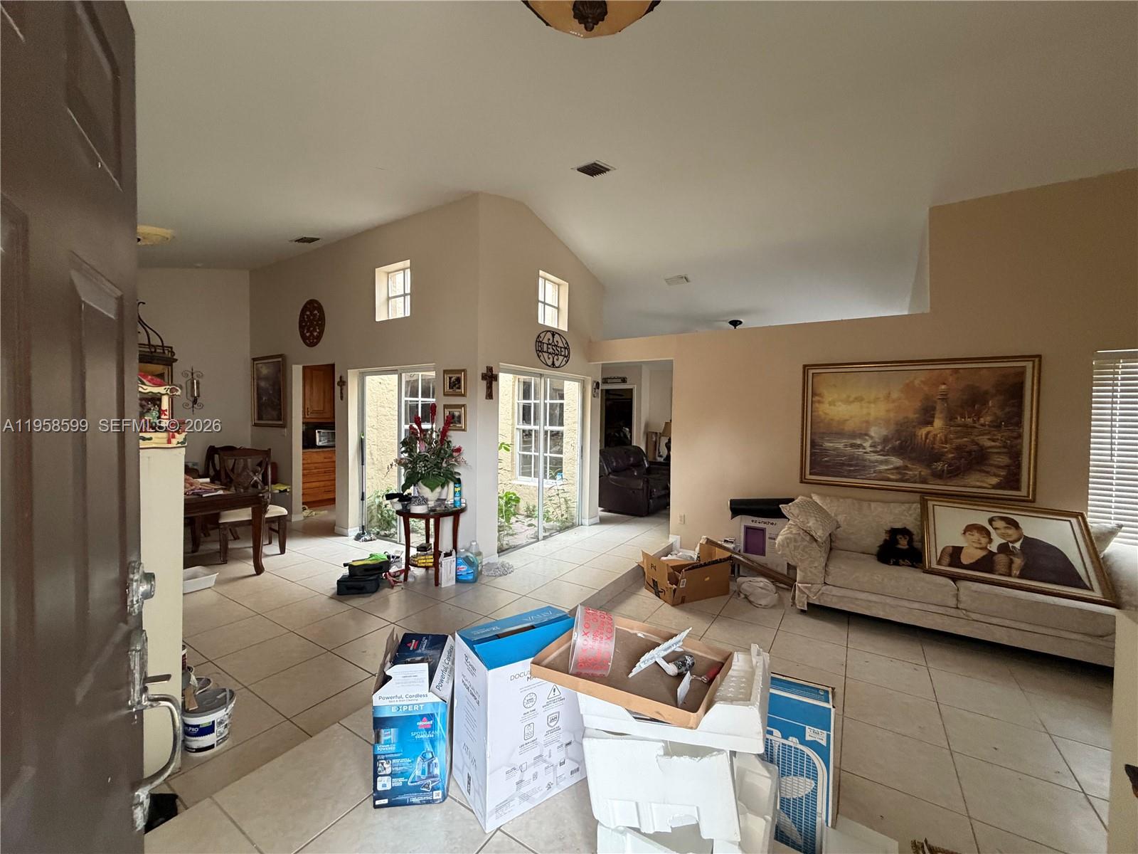 14249 Southwest 103rd Terrace Miami, FL 33186 - Photo 4 of 14 a living room with furniture a window and gym equipment