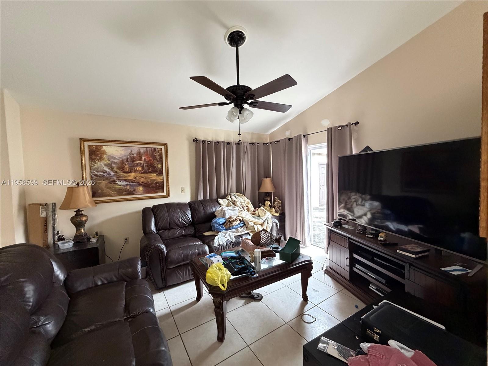 14249 Southwest 103rd Terrace Miami, FL 33186 - Photo 8 of 14 a living room with furniture and a flat screen tv