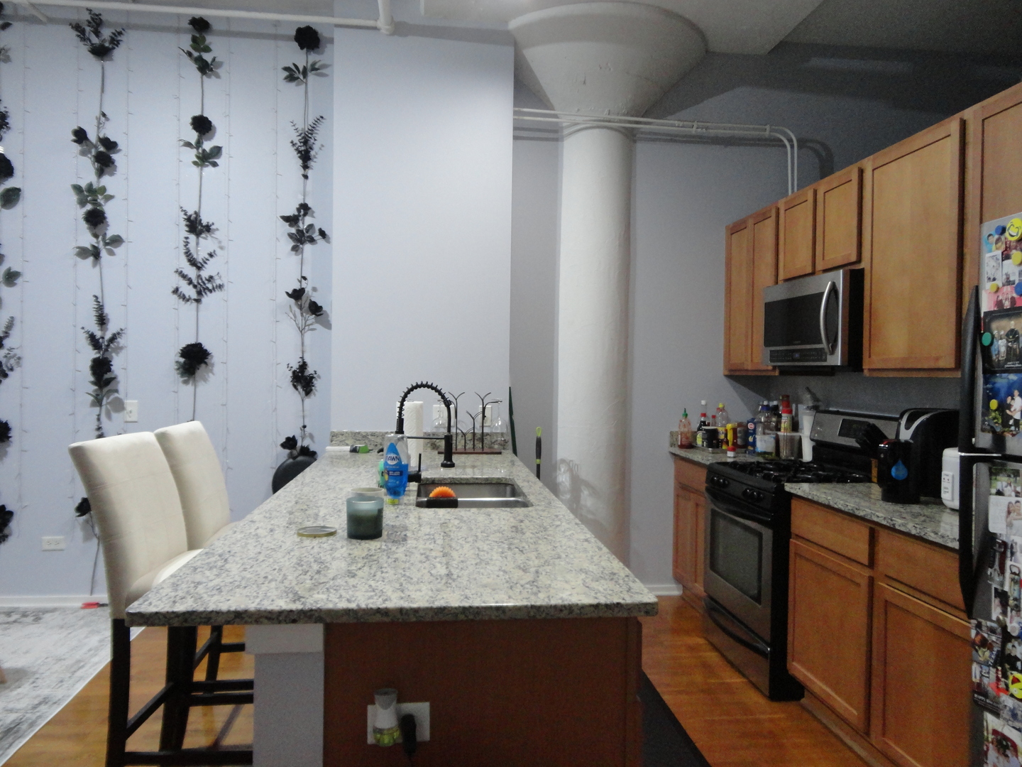 2323 West Pershing Road, Unit 237 Chicago, IL 60609 - Photo 12 of 22 a kitchen with stainless steel appliances granite countertop a sink dishwasher a stove top oven a refrigerator with island and chairs