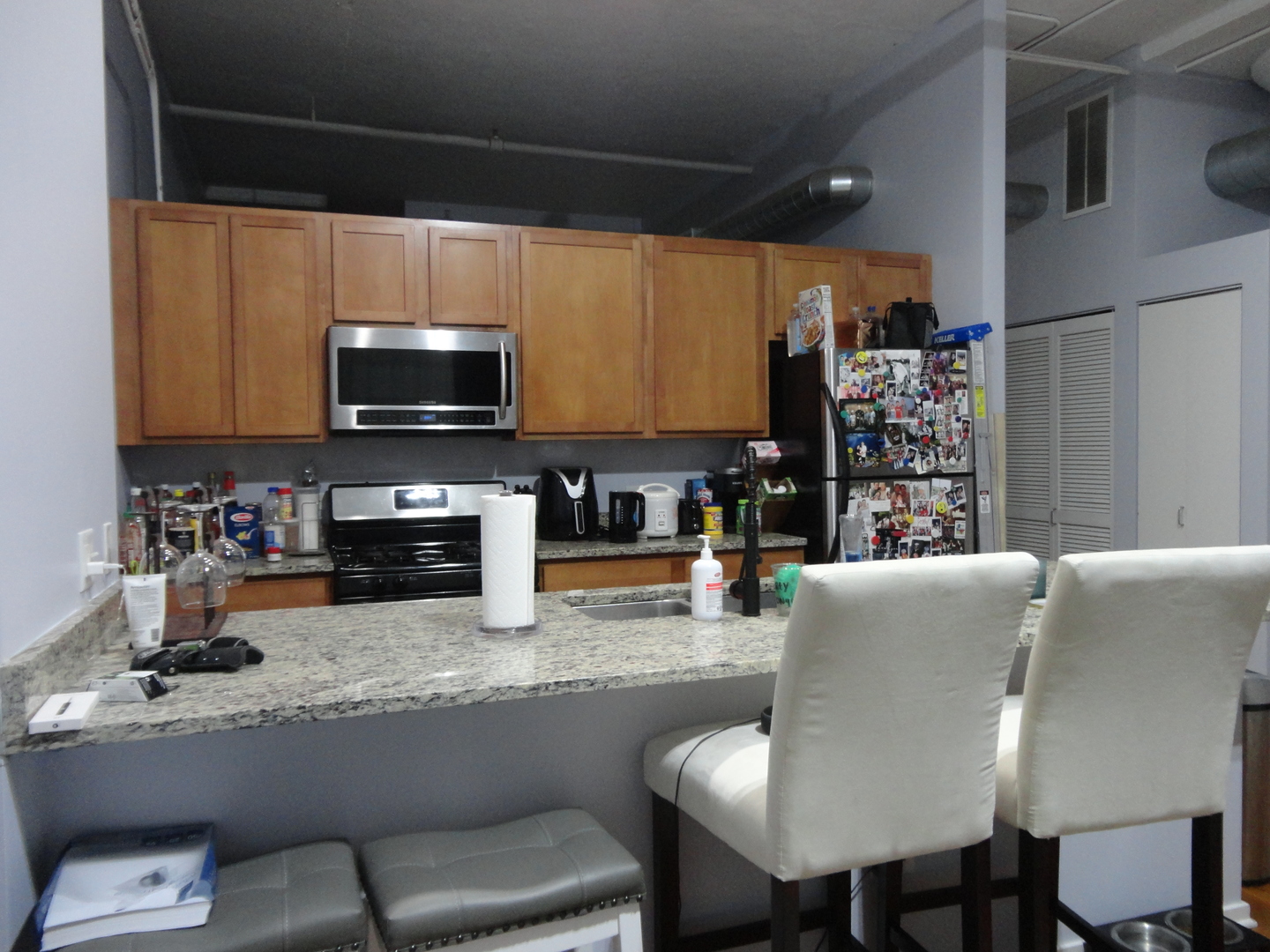 2323 West Pershing Road, Unit 237 Chicago, IL 60609 - Photo 10 of 22 a kitchen with stainless steel appliances granite countertop a sink a microwave refrigerator and chairs