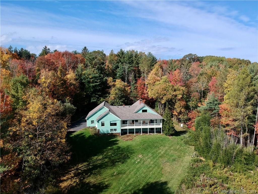 a view of a house with a yard and a forest
