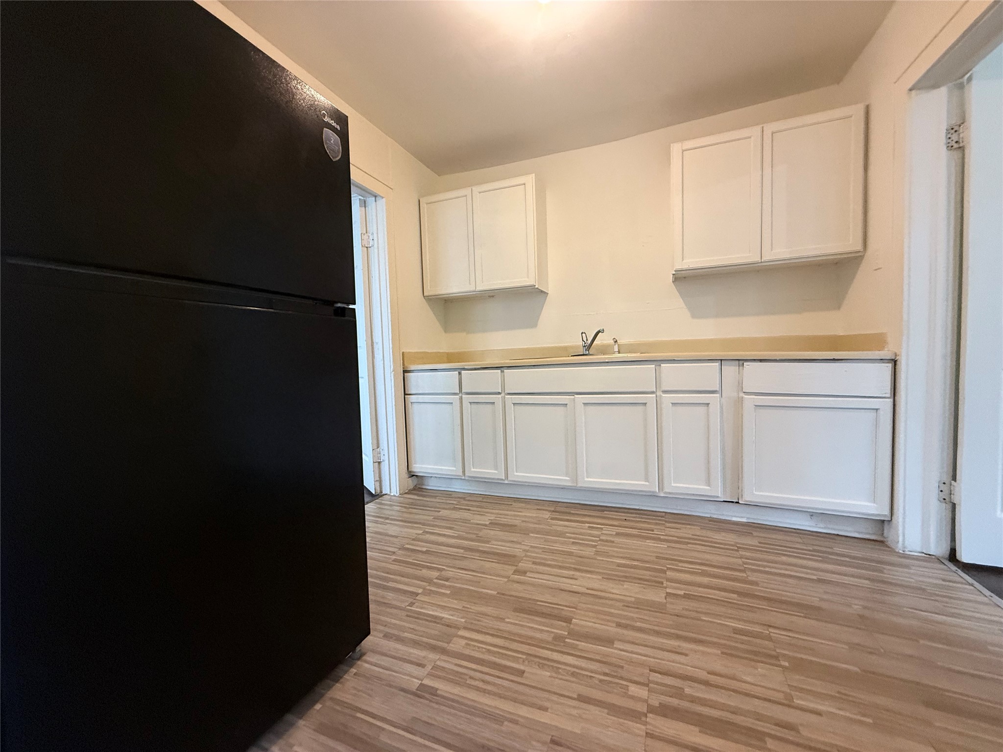 7002 Vandeman Street, Unit 5 Houston, TX 77087 - Photo 11 of 12 a view of a kitchen with wooden floor and electronic appliances